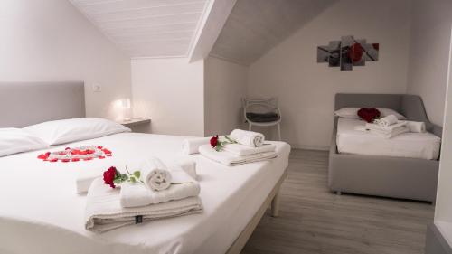 安达洛Appartamento Stella的一间卧室配有两张床、毛巾和鲜花