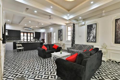 瓦加托Perfect Stay Villa and apartment的客厅配有黑色沙发和红色枕头