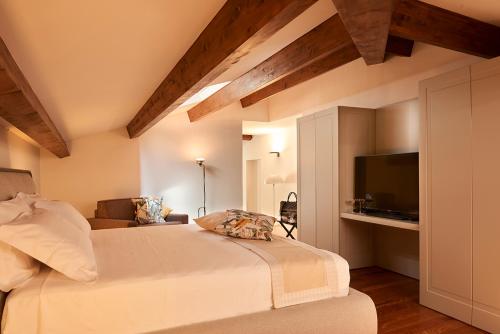 拉默齐亚泰尔默Relais - Palazzo Greco Stella的一间卧室配有一张床、一张沙发和一台电视