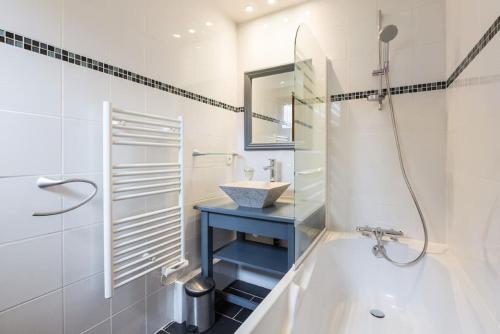 孔布卢Les Aiguilles De Warens的白色的浴室设有浴缸和水槽。
