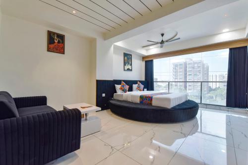 艾哈迈达巴德FabHotel Bliss的一间卧室配有一张特大号床和一张沙发