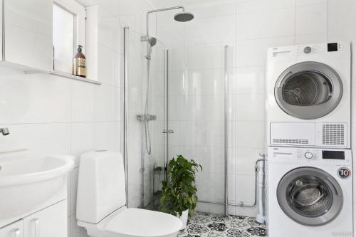 斯德哥尔摩Charming apartment in a red house in Stockholm的带淋浴和洗衣机的浴室