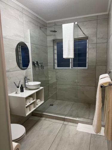 约翰内斯堡Tanelsa Apartment on West的带淋浴、卫生间和盥洗盆的浴室