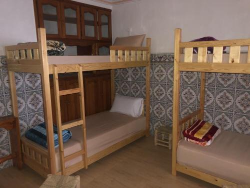 塔哈佐特Hostel blue house Taghazout的客房设有两张双层床和一张桌子。