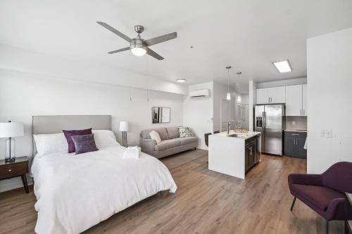 夏洛特Premium Apartments and Studios at Midtown 205 in Charlotte的白色卧室配有床和沙发