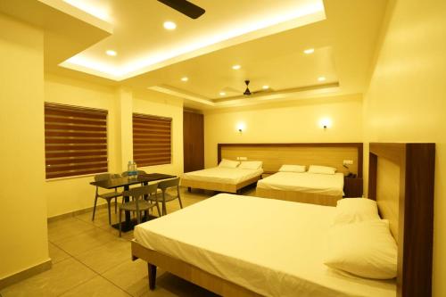 古鲁瓦尤尔SREENARAYANA TOURIST HOME的酒店客房设有两张床和一张桌子。