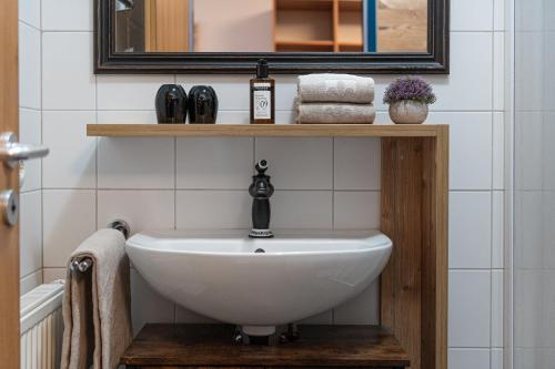 东蒂罗尔地区马特赖AlpenParks Hotel MONTANA的浴室配有盥洗盆、镜子和毛巾
