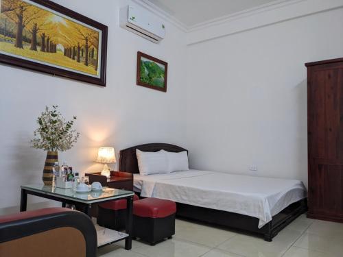 Kỳ VĩTruong Yen Hotel Ninh Binh的一间卧室配有一张床和一张桌子,桌子上配有四柱床。