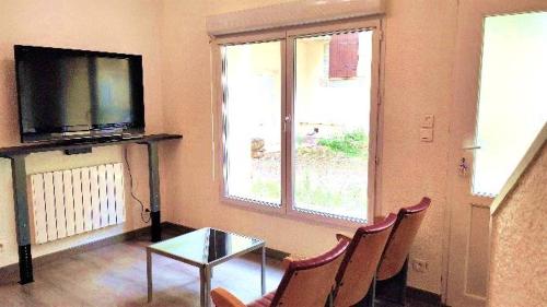 维希La Maison de Guilaine的客厅配有电视和桌椅