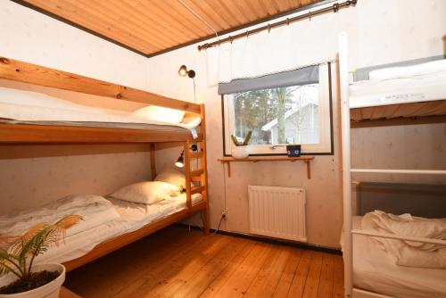 门斯特罗斯Cozy cottage on Okno near nature的客房设有两张双层床和一扇窗户。