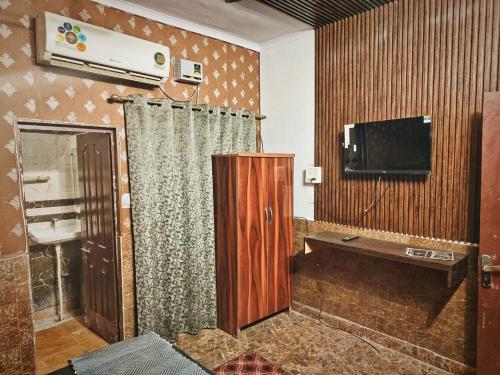 BahādurgarhMetroview rooms & hotel的一间带电视和窗帘的客厅
