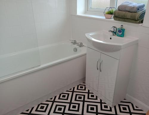 比斯特3BR House with garden near Bicester Village的白色的浴室设有水槽、浴缸和水槽。