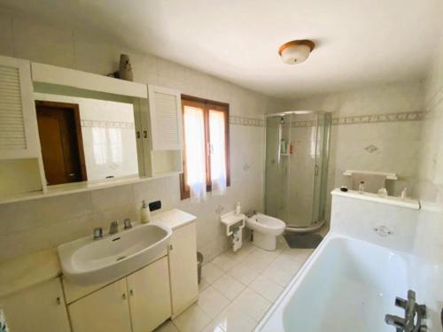 博尔戈阿莫扎诺La casa del Mike的带浴缸、盥洗盆和卫生间的浴室