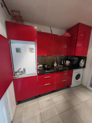 伊西莱穆利诺Sean的厨房配有红色橱柜和白色冰箱