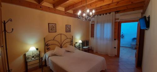 卡瓦内斯Casa Rural Forn del Sitjar的卧室配有一张白色大床和吊灯。