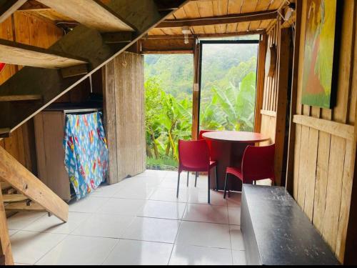 贾丁Cabaña y temazcal Mastai的客房设有桌椅和窗户。