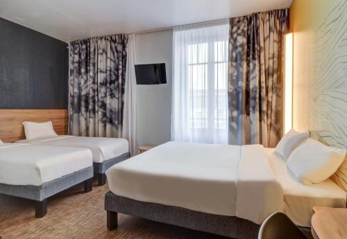 第戎B&B HOTEL Dijon Centre的一间酒店客房,设有两张床和电视