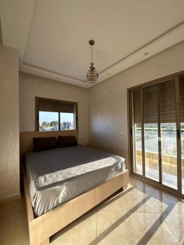 布兹尼盖Apparemment de luxe Bouznika的一间卧室设有一张床和一个大窗户