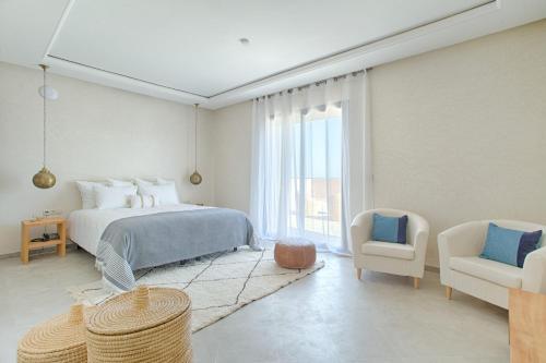 马拉喀什L'Orientale By La Siredrah的白色卧室配有床和椅子