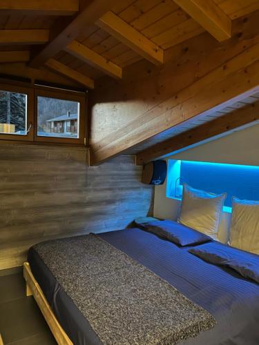 泰穆Hotel Veduta dell'Adamello的蓝色床头板的房间里一张床位