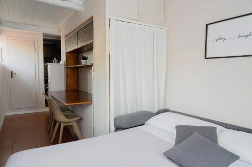 普拉托Torre al Serraglio的一间带一张床和一张书桌的卧室和一间厨房