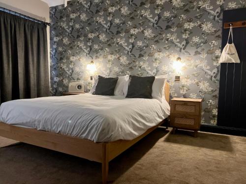 温彻斯特Kyoto Rooms Winchester的一间卧室配有一张带花卉壁纸的床