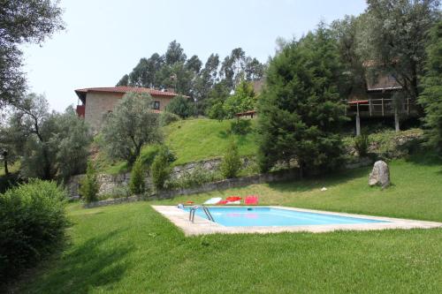 VentosaCasas do Corvo的庭院内的游泳池,后面有房子
