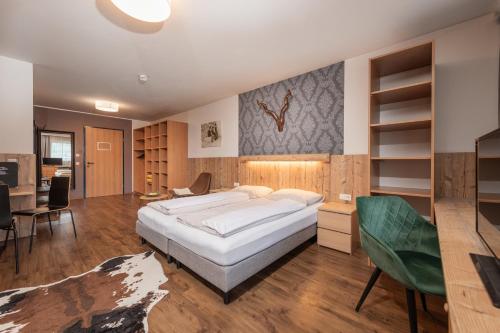 东蒂罗尔地区马特赖AlpenParks Hotel MONTANA的一间带一张白色大床和一张书桌的卧室以及一间厨房