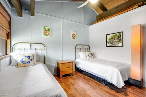 普林斯维尔Mauna Kai 8的配有白色墙壁和木地板的客房内的两张床