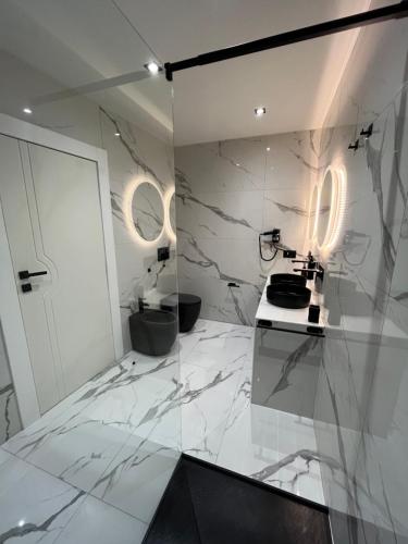 佛罗伦萨Suites - ghibellina 92的一间设有白色大理石墙壁和台面的浴室