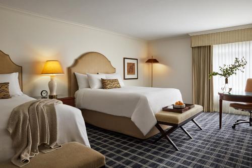 门洛帕克The Stanford Park Hotel的酒店客房配有两张床和一张书桌