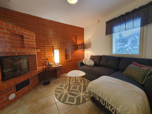 罗瓦涅米Nord Riverside的带沙发和砖墙的客厅