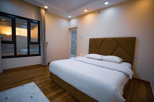 Ḩawīyahاستراحة الكثبان的一间卧室设有一张大床和一个窗户。