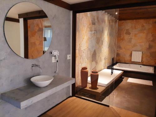 南卡希亚斯LUV Gardens Motel - Adults Only的浴室配有盥洗盆、镜子和浴缸