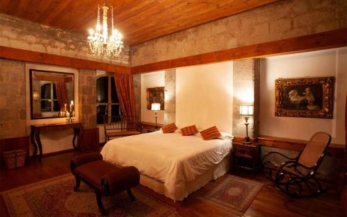 拉塔昆加拉谢内加庄园酒店的一间卧室配有一张床和一个吊灯