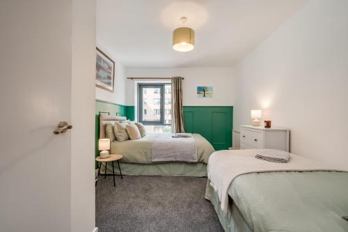 贝尔法斯特Citygate Central Apartments的绿白色客房内的两张床