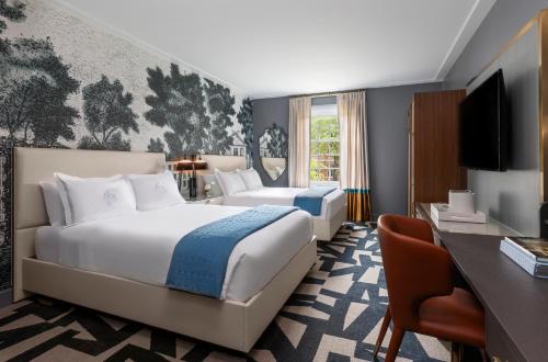 教堂山The Carolina Inn, a Destination by Hyatt Hotel的酒店客房设有一张大床和一张书桌。
