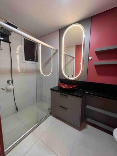 本图贡萨尔维斯Lindo e aconchegante的带淋浴、盥洗盆和镜子的浴室