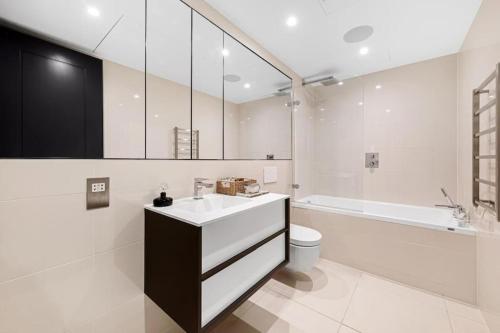 伦敦Battersea Luxury Apartment, Private, Independent Entrance, Central的浴室配有盥洗盆、卫生间和浴缸。