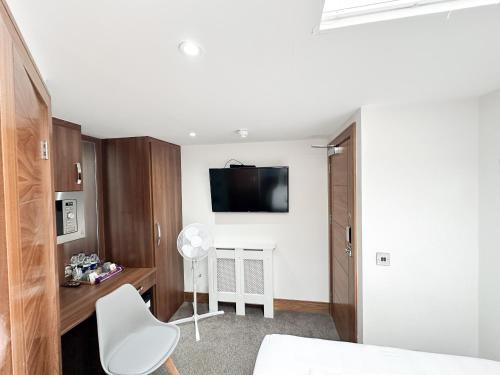伦敦205 Earls Court Rooms的卧室配有一张床,墙上配有电视。