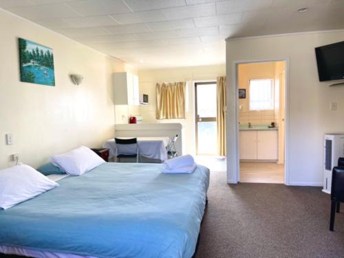 奥克兰杜克米德威酒店的一间带一张蓝色大床的卧室和一间厨房