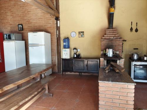 科蒂亚Chácara 4 Ases J R的一间带白色冰箱的厨房; 砖炉