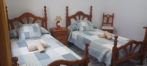 罗萨里奥港CASA LOS ABUELOS的一间卧室配有两张带蓝白色床单的床