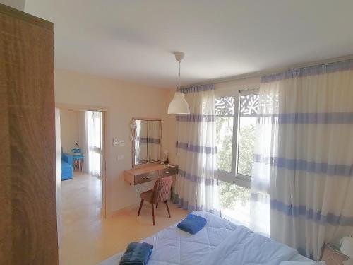 赫尔格达Mangarovy El Gouna的一间卧室配有一张床、一张书桌和一个窗户。