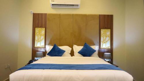 吉赞برج بيات的一间卧室配有一张带蓝白色枕头的大床