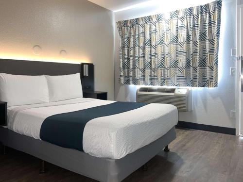 图莱里图莱里6号汽车旅馆的一间卧室设有一张大床和一个窗户。
