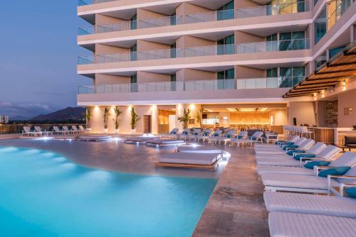 圣玛尔塔Hilton Santa Marta的酒店拥有游泳池和躺椅