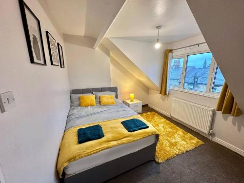 巴恩斯利Perfect Group/Contractors Home的一间卧室配有一张带黄色毯子和窗户的床