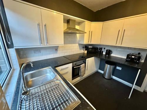 巴恩斯利Perfect Group/Contractors Home的一个带水槽和洗碗机的厨房