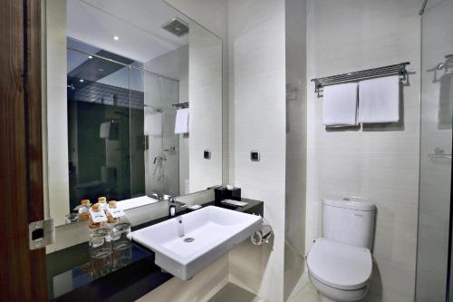 万隆Neo Dipatiukur Bandung by ASTON的浴室配有白色水槽和卫生间。